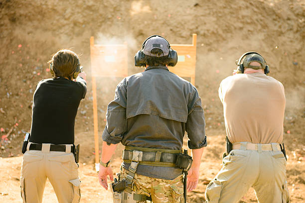 Three adults at shooting range, view from behind